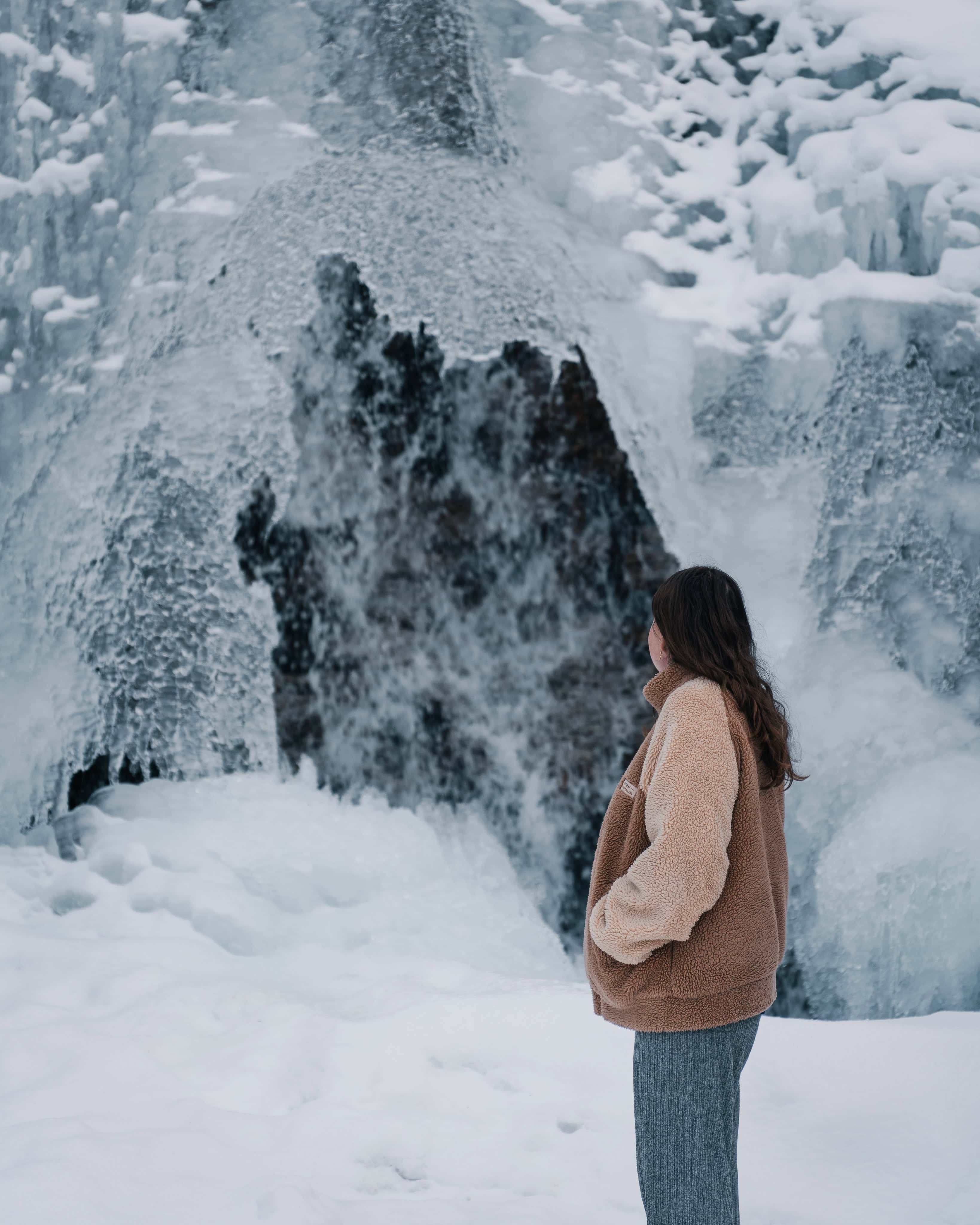 Anna in front of a frozen waterfall
